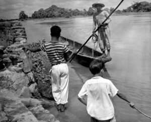 Sin título [Hombre en una curiara en la orilla del río]