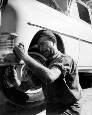 Sin título [Hombre trabajando latonería de un carro]